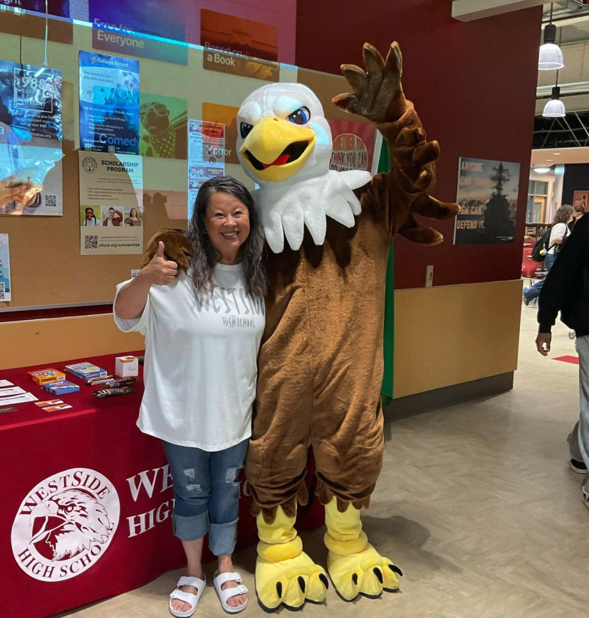 woman stands with person in an eagle costume 